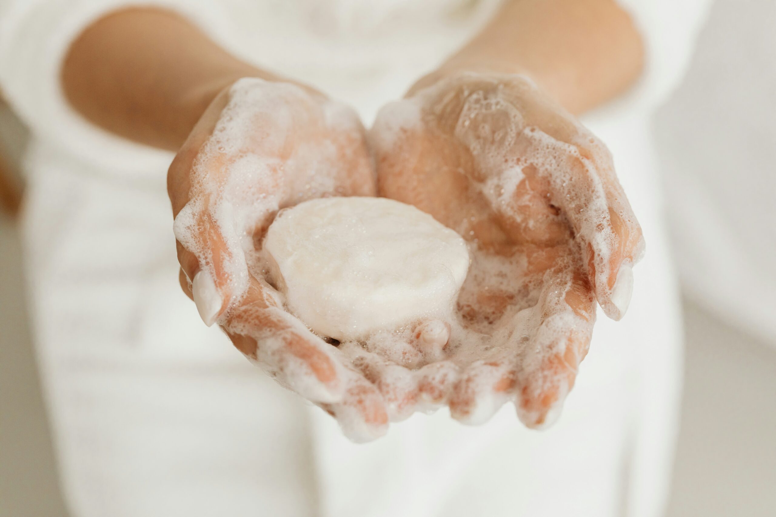 Natural Bar Soap in Use – Vanguard Private Label Soap Manufacturer Hands holding a lathered round bar of soap, emphasizing texture and natural cleansing with rich suds.